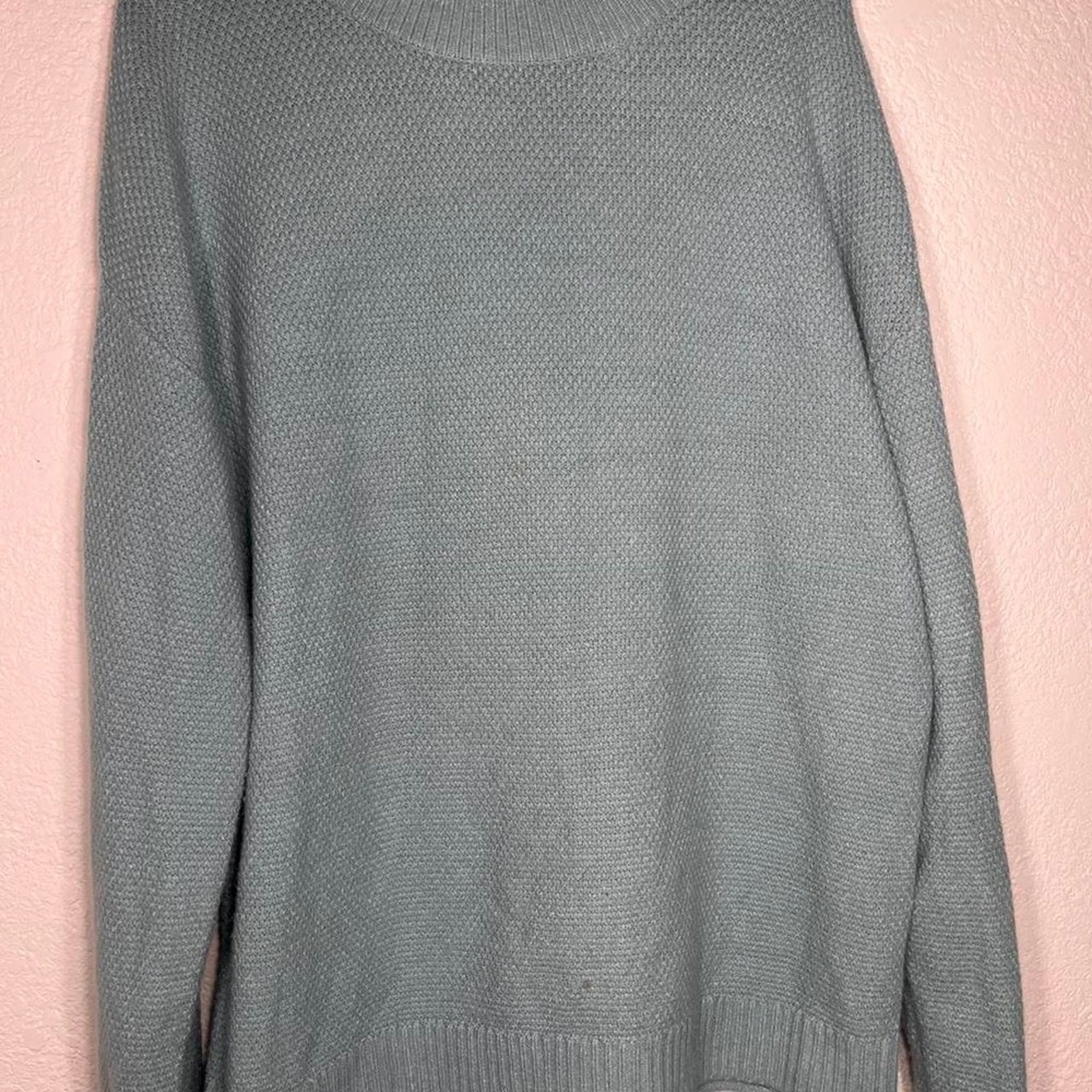 Merokeety brand sweater is a sage green, textured knit with a mock neck collar.